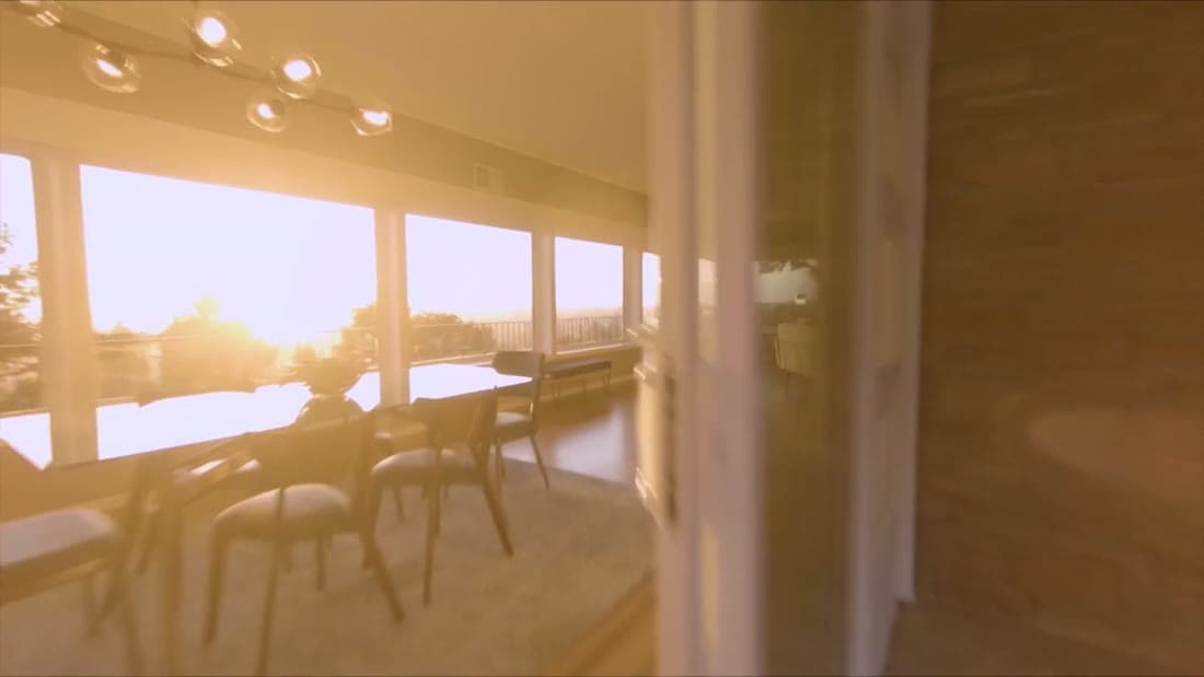 Sunlit living room with floor-to-ceiling windows at golden hour